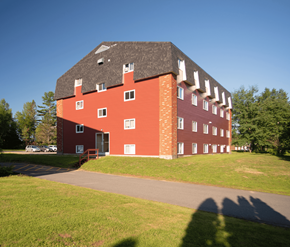 Fredericton apartment for rent - A red brick building with a black roof and white trim.
