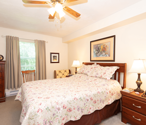 Fredericton apartment for rent - A bedroom with a large bed and a ceiling fan.