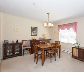 Fredericton apartment for rent - A dining room with a wooden table and chairs.