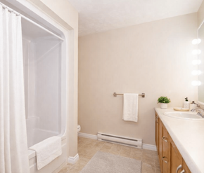 Fredericton apartment for rent - A bathroom with a white tub, sink, and towel rack.