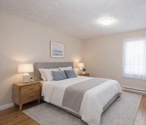 Fredericton apartment for rent - A bedroom with a bed, nightstand, and lamp.