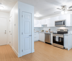Saint John apartment for rent - A kitchen with a white door and appliances.
