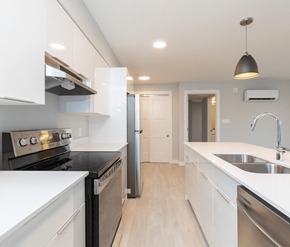 Courtenay apartment for rent - A modern kitchen with white cabinets and stainless steel appliances.