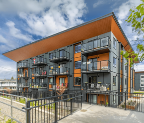 Courtenay apartment for rent - A modern building with black and orange exterior and balconies.