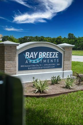 Bay City apartment for rent - a sign for bay breeze apartments in front of a grass field
