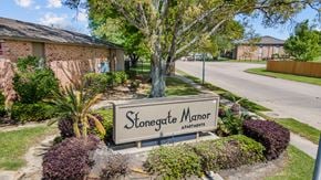 Port Arthur apartment for rent - a sign that says stonegate manor apartments in front of a brick building