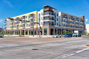 Houston apartment for rent - a large apartment building on the corner of a street with cars parked in front of it