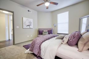 Houston apartment for rent - a bedroom with a large bed and a ceiling fan