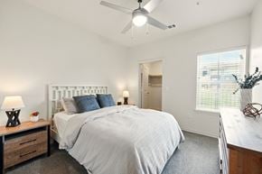 Lake Charles apartment for rent - A bedroom with a large bed and a ceiling fan.