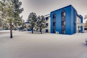 Denver apartment for rent - A blue building is surrounded by snow.