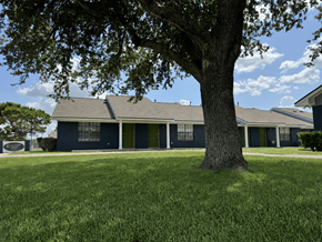 Port Arthur apartment for rent - A tree stands in front of a blue house.