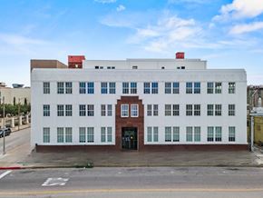 Galveston apartment for rent - A white building with a red door and windows on the side.