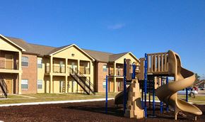 Orange apartment for rent - a playground with a slide in front of an apartment building