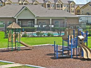 Orange apartment for rent - a playground with a slide and other toys in front of a house