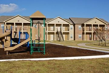 Orange apartment for rent - an empty playground in front of an apartment complex