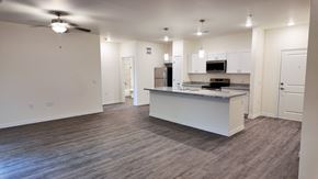 Beaumont apartment for rent - A spacious kitchen and living room with a ceiling fan and hardwood floors.