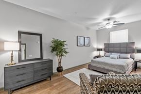 Shreveport apartment for rent - a bedroom with a bed and a dresser with a mirror