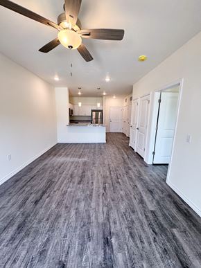 Beaumont apartment for rent - A room with a ceiling fan and a kitchen area in the background.