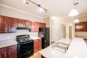 Beaumont apartment for rent - A kitchen with brown cabinets and black appliances.