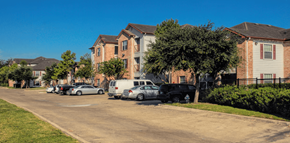 Houston apartment for rent - A residential street with houses on both sides and cars parked along the curb.
