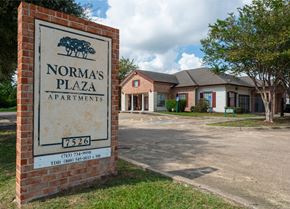Houston apartment for rent - A sign for Norma's Plaza Apartments stands in front of the building.