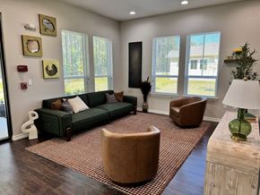 Lumberton apartment for rent - A living room with a green couch, brown armchair, and a wooden coffee table.