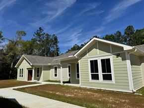 Lumberton apartment for rent - A house with a grey roof and white trim is shown with a clear blue sky in the background.