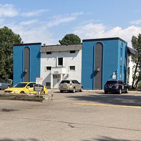 Denver apartment for rent - A yellow car is parked in front of a white and blue building.