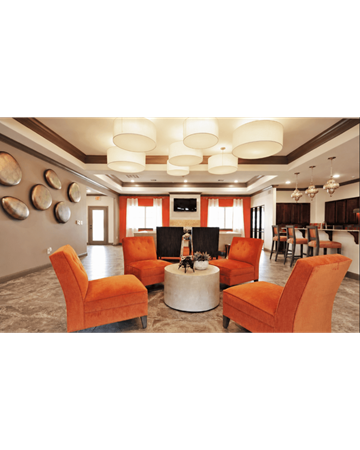Orange apartment for rent - A living room with orange chairs and a fireplace.