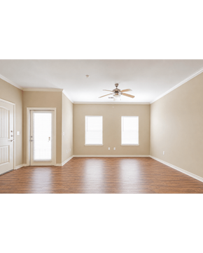 Orange apartment for rent - A room with a ceiling fan and three windows.