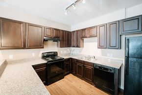China apartment for rent - a kitchen with dark wood cabinets and white countertops