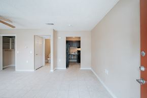 Port Arthur apartment for rent - a living room with a tiled floor and a kitchen in the background