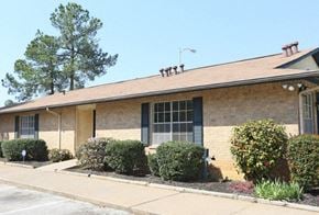 Longview apartment for rent - a brick building with bushes and a sidewalk