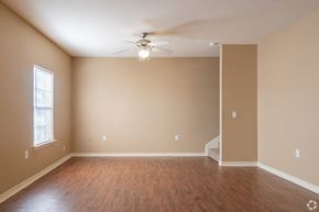 Orange apartment for rent - an empty living room with wood floors and a ceiling fan