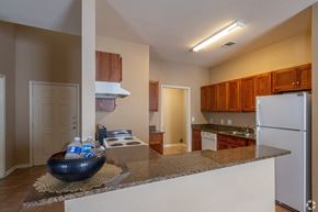 Orange apartment for rent - a kitchen with a granite counter top and a white refrigerator