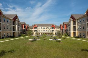 Beaumont apartment for rent - an outdoor courtyard with picnic tables in front of an apartment building