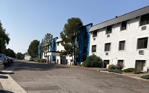 Denver apartment for rent - A white building with a blue stripe on the side is in the background.
