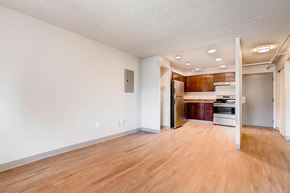 Denver apartment for rent - A room with wooden floors and white walls.