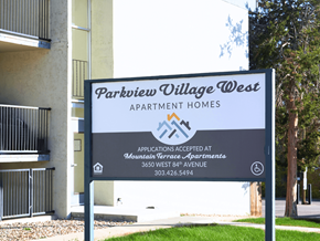Arvada apartment for rent - A sign for Parkview Village West Apartment Homes is displayed in front of a building.