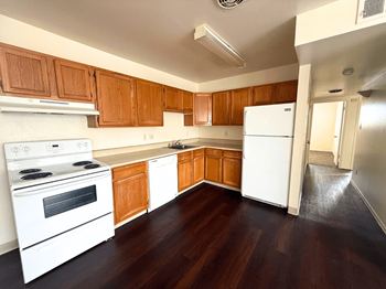 A kitchen with white appliances and wooden cabinets.