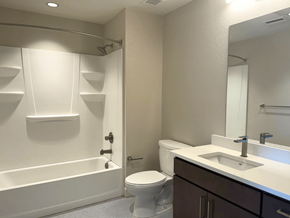 Denver apartment for rent - A white bathroom with a toilet, sink, and bathtub.