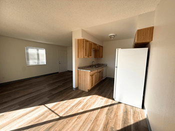 A kitchen with wooden floors and white walls.