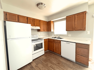 Westminster apartment for rent - A kitchen with white appliances and wooden cabinets.