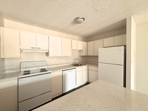 Arvada apartment for rent - A kitchen with white appliances and cabinets.