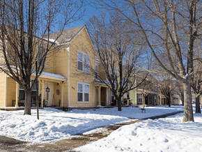 Greeley apartment for rent - A yellow house with snow on the ground and bare trees at Meeker Commons Apartments, Greeley