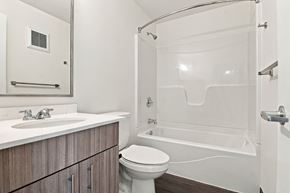 Fort Morgan apartment for rent - A white toilet sits next to a sink in a bathroom at Gateway Village Apartments in Fort Morgan, CO, 80701