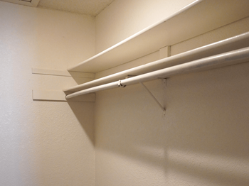 A white wall with a white shelf attached to it.