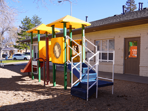 Westminster apartment for rent - A playground with a yellow and green structure and a blue slide at Mountain Terrace Apartments, Westminster, CO, 80031.