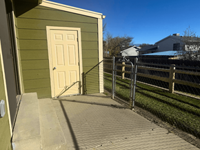 Clifton apartment for rent - A small green building with a white door and a metal fence at Willow Grove Apartments, Clifton, CO.