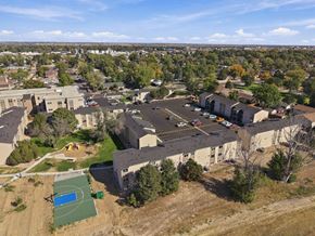 Fort Morgan apartment for rent - A bird's eye view of a residential area with apartment buildings, a swimming pool, and a parking lot at Gateway Village Apartments in Fort Morgan, CO, 80701